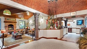 A spacious living area with a fireplace, a stone pillar, and a large window with a view. - +MS +Casa Tequis +Hermoso Jardín (Tequisquiapan)