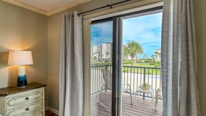 A room with a view of a balcony, a lamp, and a dresser. - Ocean Club 38 (St. Augustine)