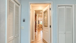 A hallway with a tiled floor leading to a dining area. - Ocean Club 38 (St. Augustine)