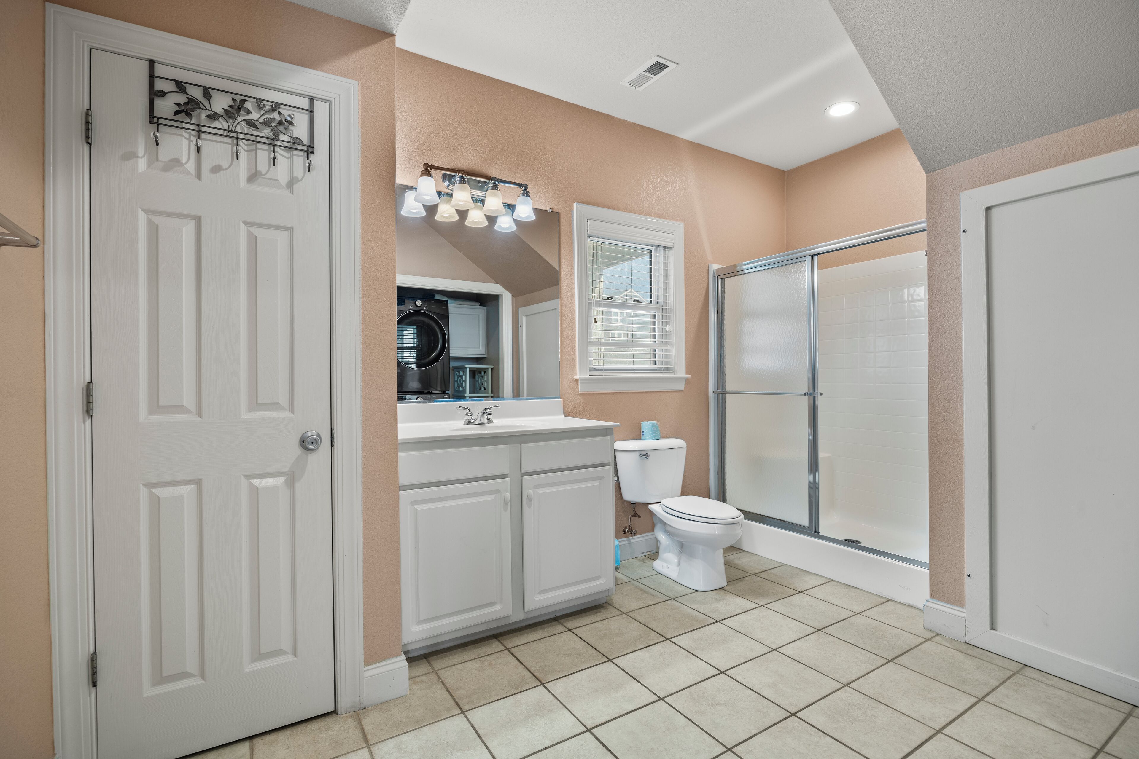 Une salle de bain avec une porte blanche, un lavabo, des toilettes et un espace douche.