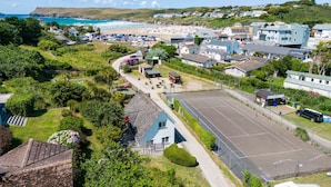 A coastal town with a beach, houses, and a parking area. - Baywatch Sands (Wadebridge)