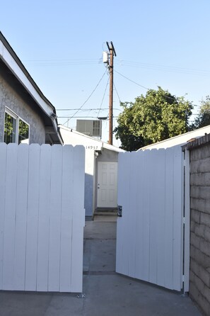 A gated driveway leading to a house with a mailbox and a number 14957 on the door.