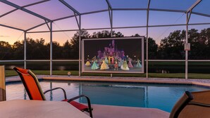 A pool area with a large screen displaying a castle scene.