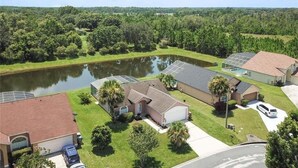 A residential area with houses, a pond, and solar panels.