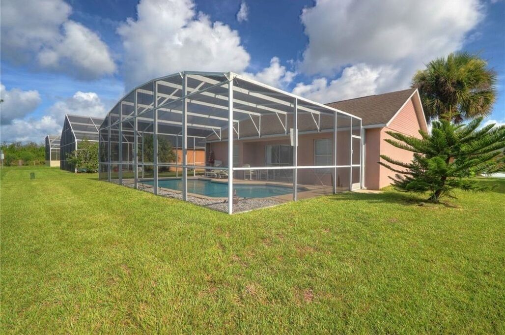 A house with a covered patio area and a swimming pool.