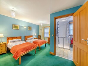 A bedroom with two beds, a shower, and a door leading to another room. - 3 bedroom accommodation in Cowshill, near Alston (Cowshill, near Alston)