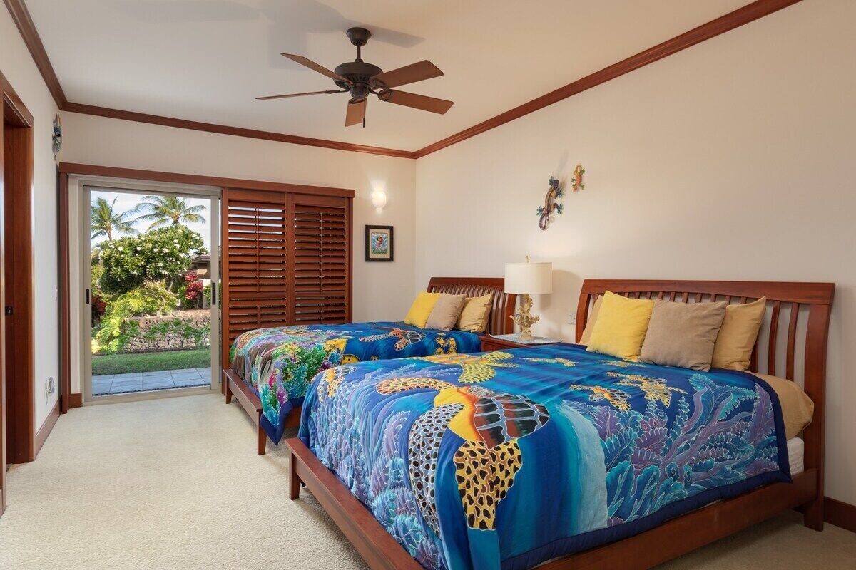 A bedroom with a bed, a ceiling fan, a window with blinds, and a view of the outdoors.