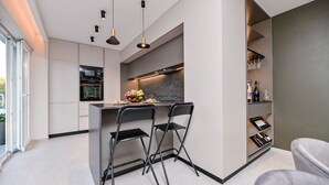 Cocina moderna con isla central, taburetes de bar y estante para vinos.