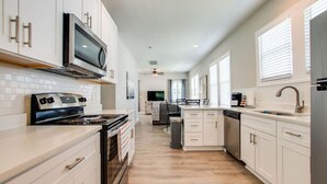 A modern kitchen with white cabinets, a stainless steel range, and a built-in microwave. - Little Stone House in the Heart of Murfreesboro (Murfreesboro)