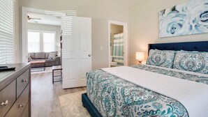 A bedroom with a bed, a dresser, a sofa, and a painting on the wall. - Little Stone House in the Heart of Murfreesboro (Murfreesboro)