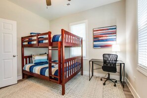 Ein Zimmer mit einem Etagenbett, einem Schreibtisch und einem Stuhl.
