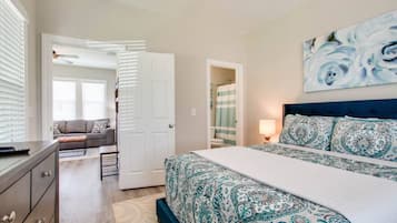 Een slaapkamer met een bed, een kaptafel, een bank en een schilderij aan de muur.