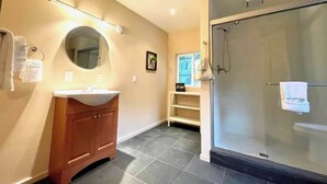 A modern bathroom with a glass shower, a wooden vanity, and a round mirror. - #3 Hemlock Olympic Nat’l Park - Private Rm in Forest (Port Angeles)