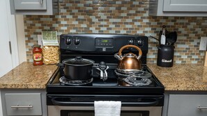A kitchen with a stove, pots, a kettle, and a jar of pasta. - Gorgeous Pet Friendly Townhome: Clean and Spacious With Private Terrace! (Edinburg)