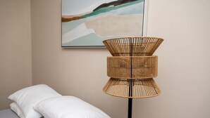 A room with a bed, white pillows, a woven floor lamp, and a painting on the wall. - Gorgeous Pet Friendly Townhome: Clean and Spacious With Private Terrace! (Edinburg)