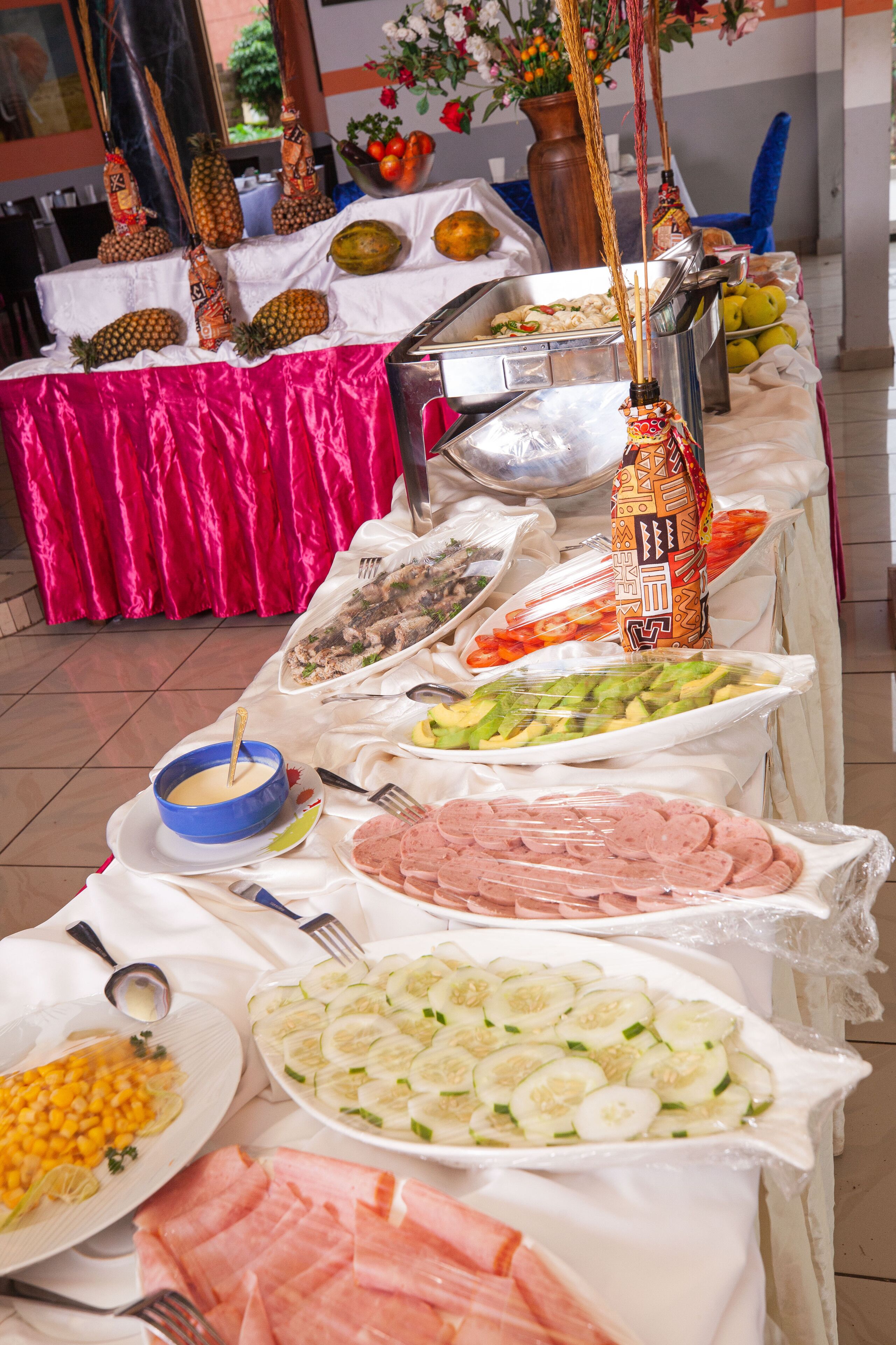 A buffet table with various food items and utensils.