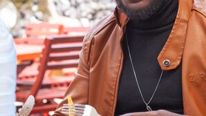 A person seated at a table with a plate of food, a fork, and a knife. - FELICIA HÔTEL (Yaoundé)