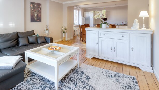 A modern living room with a sofa, coffee table, and white cabinets. - The spacious vacation apartment for 9 people is ideal for excursions. (Thale/OT Neinstedt)