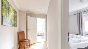 A bedroom with a bed, a chair, and a door leading to an outdoor area. - The spacious vacation apartment for 9 people is ideal for excursions. (Thale/OT Neinstedt)
