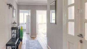 A hallway with a bench, a potted plant, and a mirror on the wall. - The spacious vacation apartment for 9 people is ideal for excursions. (Thale/OT Neinstedt)