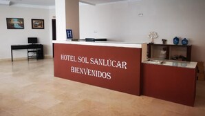 Een receptiebalie van een hotel met een bordje waarop staat: HOTEL SOL SANLUCAR BIENVENIDOS.
