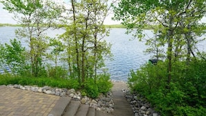 A stone staircase leading to a lakeside area with a view of the water. - Morning Sun Cabin on Lake Metigoshe (Bottineau)