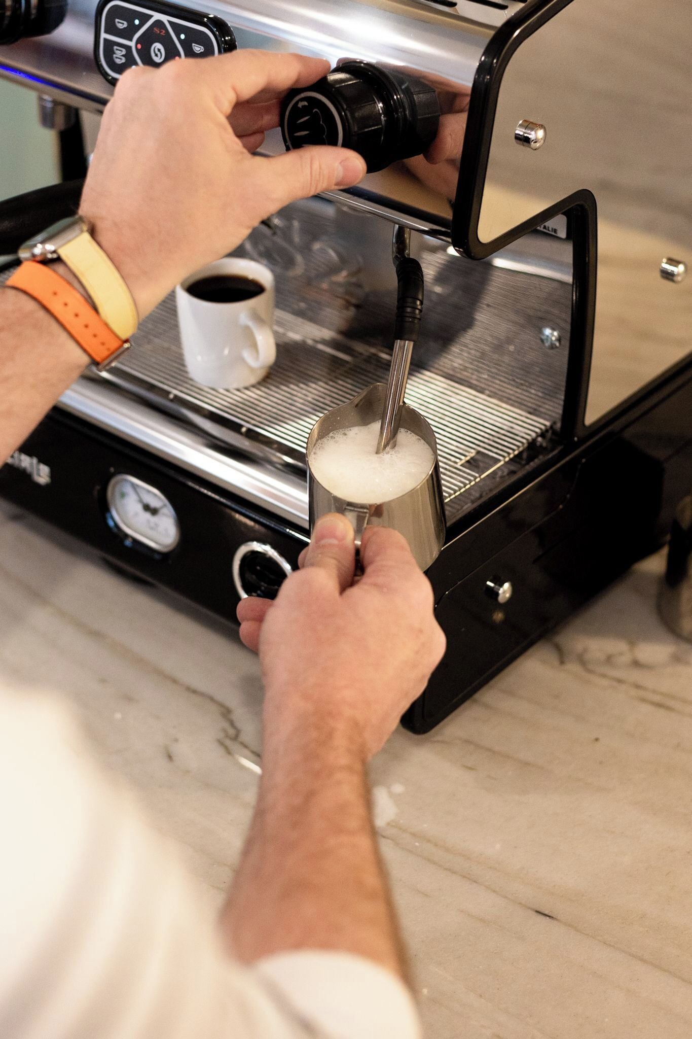 Una persona usando una máquina de café para servir café en una taza.