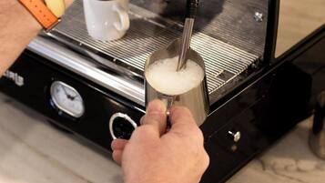 Una persona usando una máquina de café para servir café en una taza.