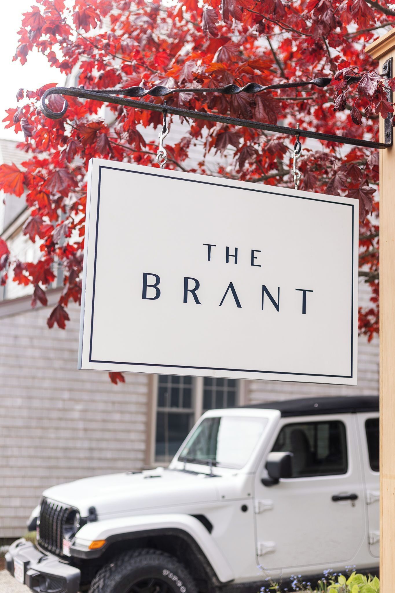 Une enseigne portant l’inscription « THE BRANT » est suspendue au-dessus d’un véhicule blanc.