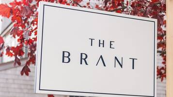 Une enseigne portant l’inscription « THE BRANT » est suspendue au-dessus d’un véhicule blanc.