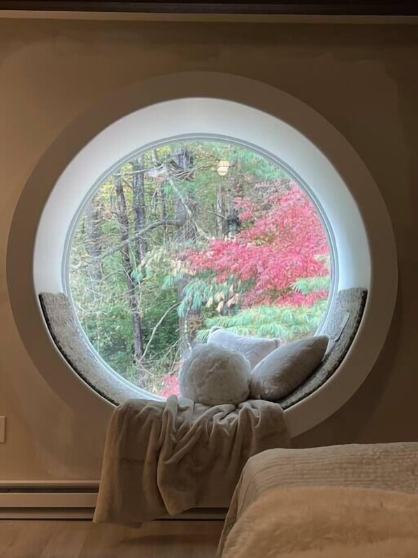A round window with a view of trees and foliage.