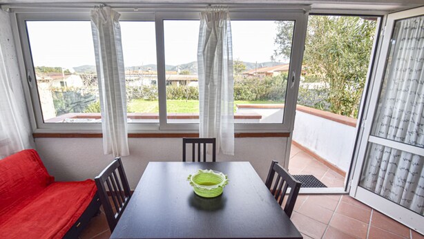 A balcony with a dining table, chairs, and a red sofa. - CASA GINESTRA - GINESTRA 2 (Campo nell'Elba)