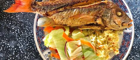 A plate with grilled fish and vegetables.