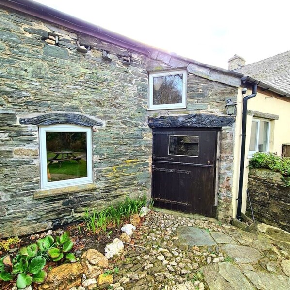 A stone building with a black door and a window above it. - Ta Mill Forge Cottage in a Stunning Retreat (Launceston)