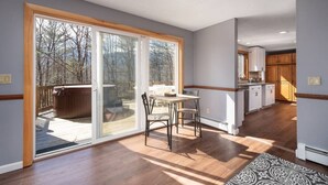Cocina amplia con un gran ventanal corredero que da a una terraza, piso de madera e isla integrada con asientos.