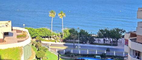 Zona residencial con piscina, palmeras y vistas al mar.
