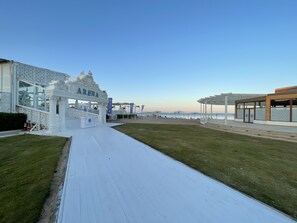 A beachside area with a white pathway leading to a building labeled 'ARENA'.