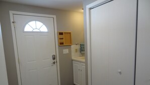 A hallway with a white door, a small window, a wooden cabinet, and a white closet. - Close to Mayo/Shops, 1 step entry Covered By Faith (Rochester)