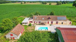 A large farmhouse with a swimming pool, surrounded by expansive green fields and a forest in the background. - So Villa Noé Michel (72) - Heated pool - Basketball - 2h Paris - 30 p. (Vallon-sur-Gée)