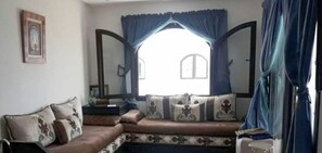 Relax in this inviting living room with a comfortable sofa, framed artwork, and a large window.