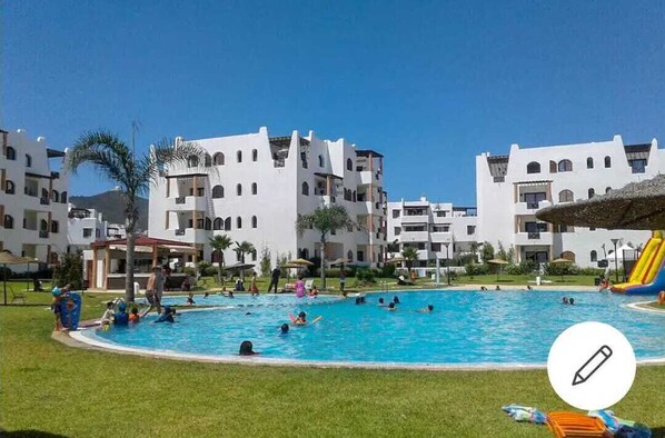 Guests can enjoy a refreshing swim in the resort pool surrounded by lush greenery.