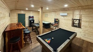 A wooden-paneled room with a pool table, bar stools, and arcade games. - Cabin Apt 20min to Gatlinburg across from Ntl Park GameRoom+FirePit+Pet Friendly (Cosby)