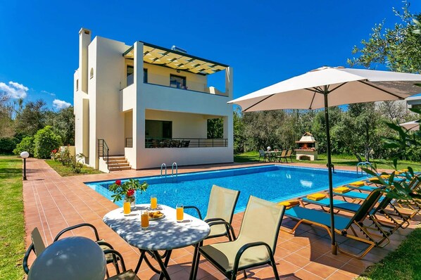 A modern two-story house with a swimming pool, outdoor seating, and a barbecue area. - Villa Ilos by Villa Plus (Pyrgos Psilonerou)