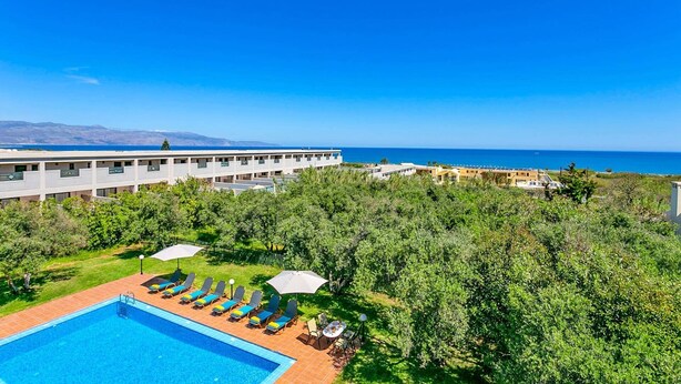 A hotel with a swimming pool, sun loungers, and a view of the sea. - Villa Ilos by Villa Plus (Pyrgos Psilonerou)