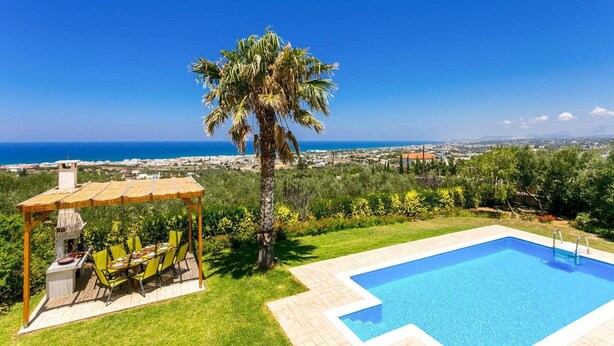 Una piscina con vista sul mare, un padiglione con posti a sedere all'aperto e una palma.