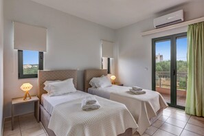 A hotel room with two beds, a balcony, and an air conditioning unit. - Villa Katerina Pente by Villa Plus (Kalives)