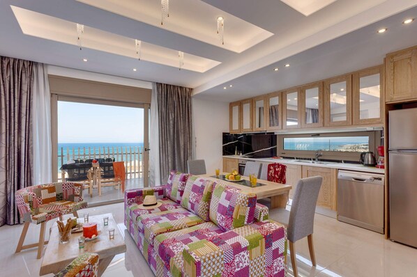 A modern living room with a colorful sofa, a dining area, and a kitchen with wooden cabinets.