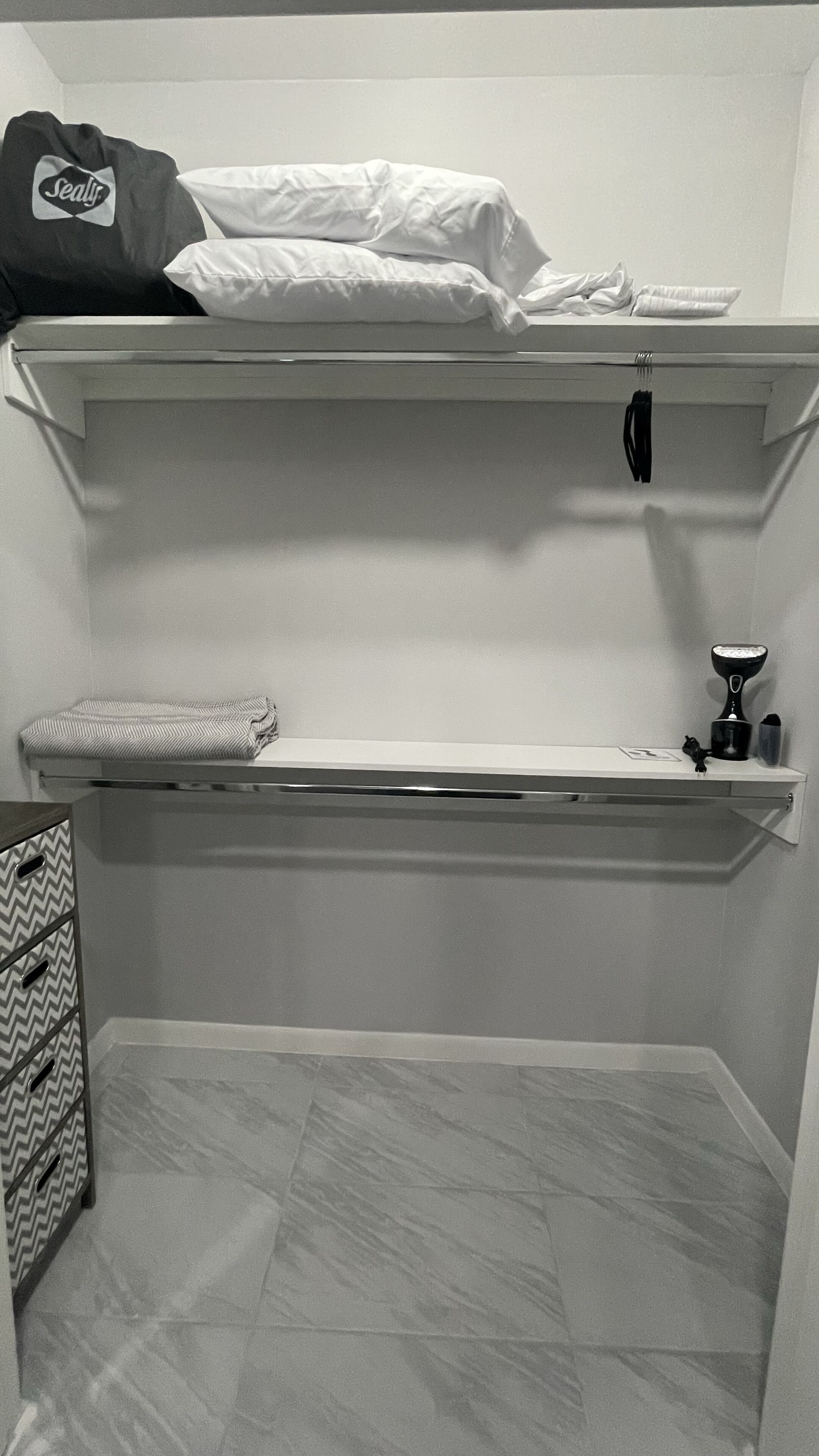 Une petite pièce, de taille modeste, comprenant un lit superposé, un bureau et une chaise.