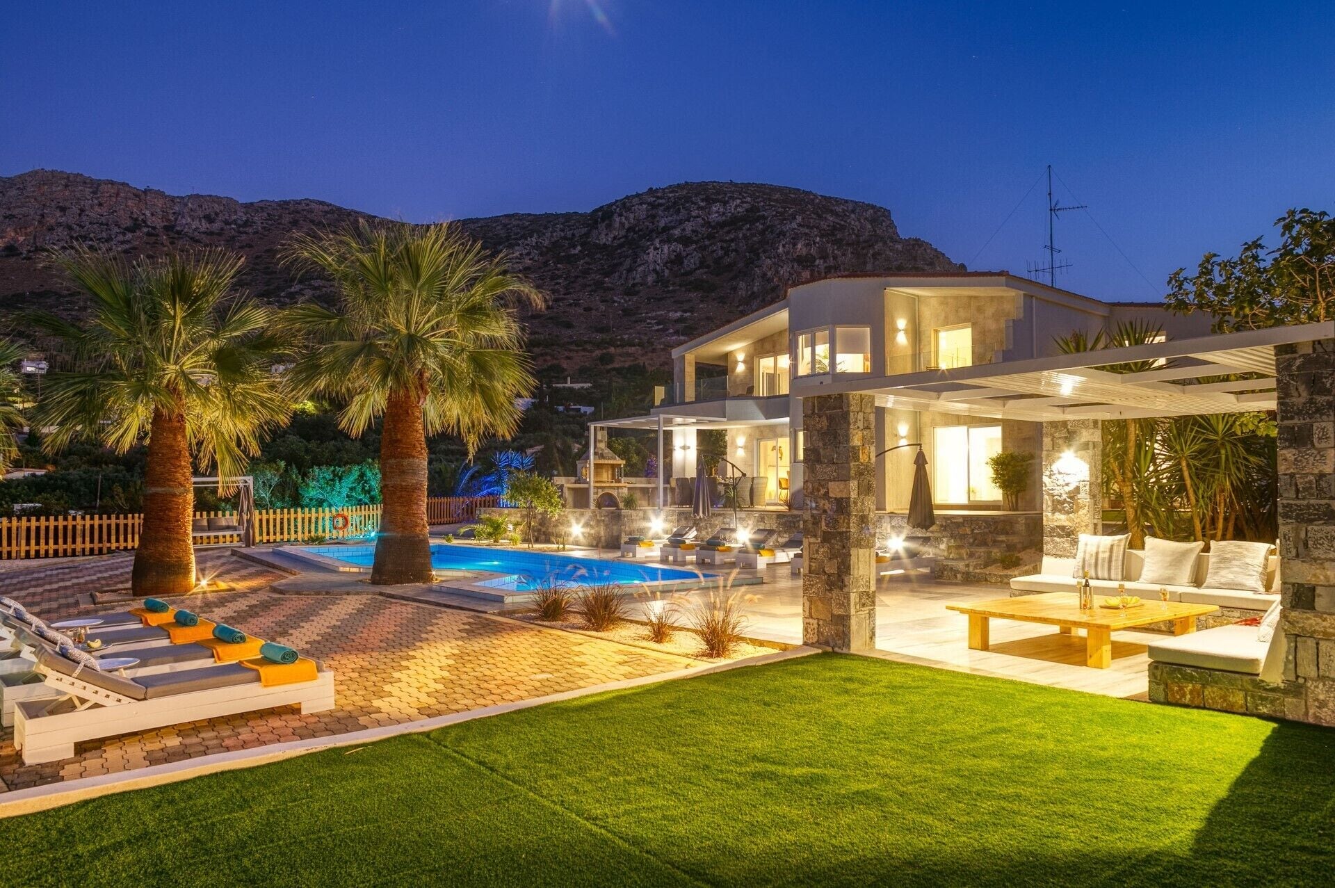 Une villa moderne dotée d’une piscine, d’un espace salon extérieur et offrant une vue sur les montagnes.