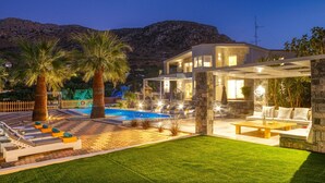 A modern villa with a swimming pool, outdoor seating, and a view of the mountains. - Villa Monroe by Villa Plus (Hersonissos)